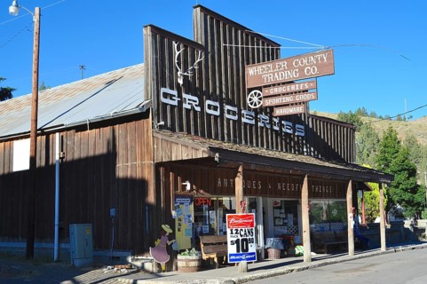 A shop with a wooden façade and several signs identifying the shop as a retail space, Mitchell,