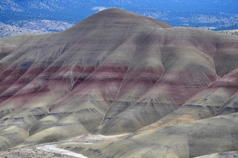 Reddish brown hills with gentle curves and eroded areas against a clear sky, John Day Fossil Beds