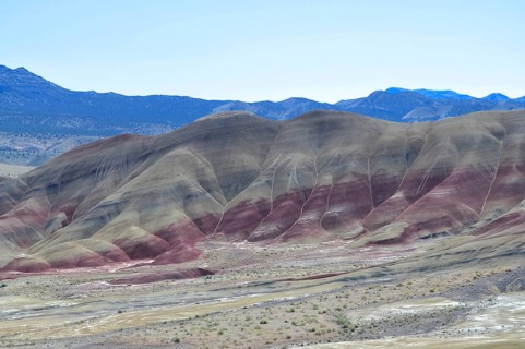 Colourful hills with red stripes under clear skies. Impression of an eroded geological formation,