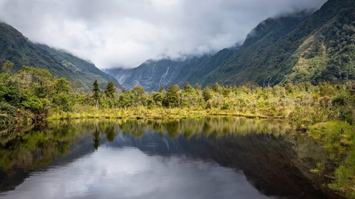 Peter's pool, glacier valley, mountains and glaciers in clouds. Westland Tai Poutini National Park,