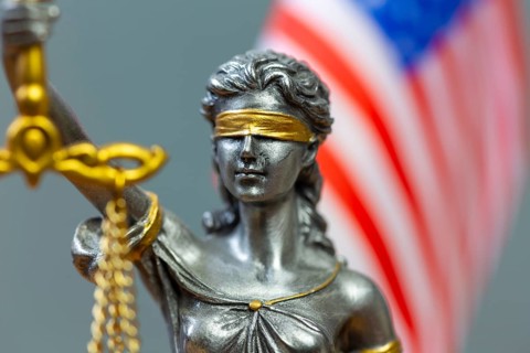 Close-up of a Justitia in front of the flag of the USA (symbolic image)