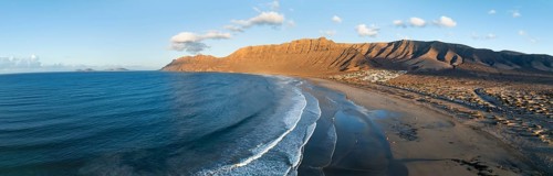 Panorama, Risco de Famara cliffs and sea with Famara beach, in the evening light, Playa de Famara,