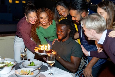 A lively group of friends celebrating a special occasion They gather around a table, smiling and