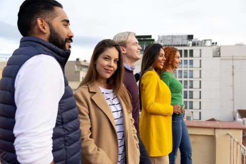 A cheerful group of friends enjoys a rooftop gathering, creating joyful memories with smiles and