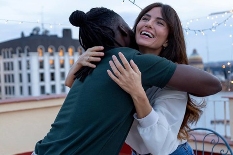 Two friends embrace joyfully on a rooftop, celebrating a party full of happiness and connection The