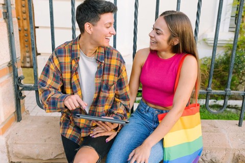 A joyful lesbian couple enjoys a happy moment outdoors, sharing smiles and warmth. They represent
