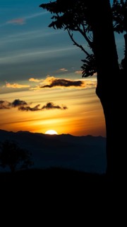Captivating scene of the sun setting behind the silhouetted mountains, viewed from a vantage point