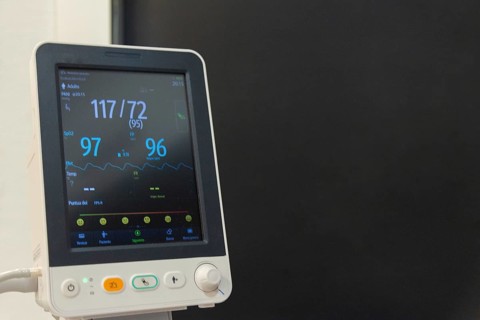 A mature woman is being monitored for vital signs like heart rate and blood pressure in a hospital