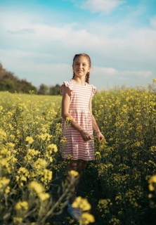 A school-age girl in a field of flowers in summer. Childhood and nature