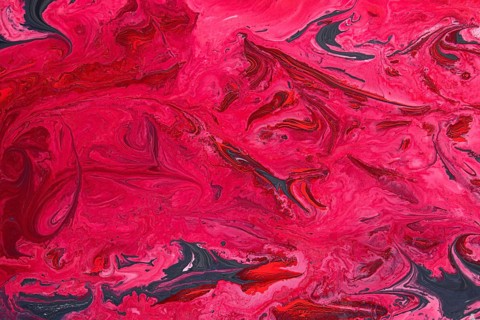 A striking abstract marble texture featuring vivid shades of acrylic red and pink, intertwined with