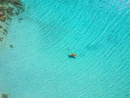 A stunning aerial view of Diaporos Island in Greece, showcasing crystal-clear turquoise waters with