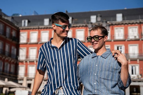 A joyful gay couple walking through the vibrant streets of Madrid, showcasing love and diversity in