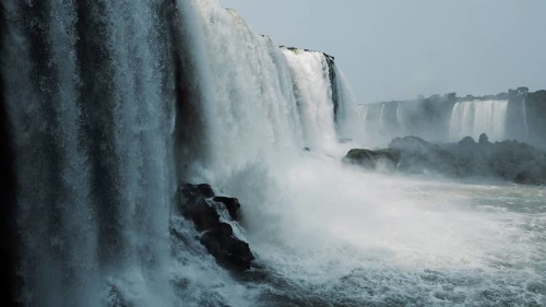 Stunning capture of the powerful Iguazu Falls surrounded by mist and plunging into the river at the