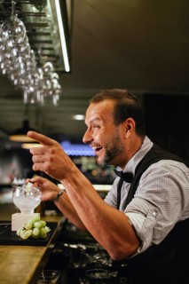 Professional bartender crafting cocktails in a chic bar. The atmosphere is lively and