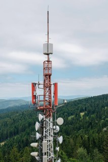 A towering communication array equipped with various antennas and dishes, standing against a