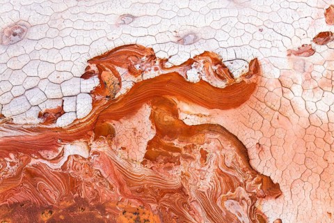 Vibrant and textured aerial view of abstract red and white rock formations, showcasing intricate