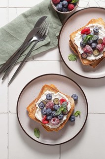 Top view of delicious breakfast setup featuring toast slathered with cream cheese and topped with