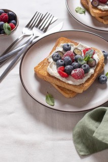 Delicious serving of toast topped with cream cheese and a generous selection of fresh berries