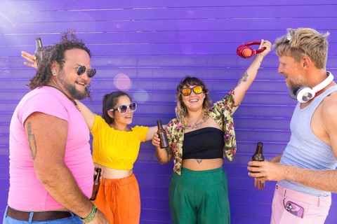 Vibrant group of LGBTQIA+ friends enjoying a sunny day together. They share laughter, drinks, and