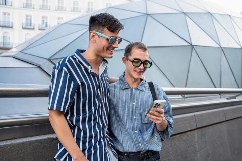 A cheerful gay couple enjoys a day out in the vibrant streets of Madrid, capturing moments on their