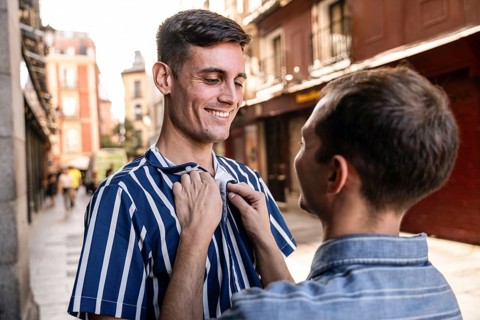 A gay couple shares a tender moment on the streets of Madrid. Capturing love and connection in a