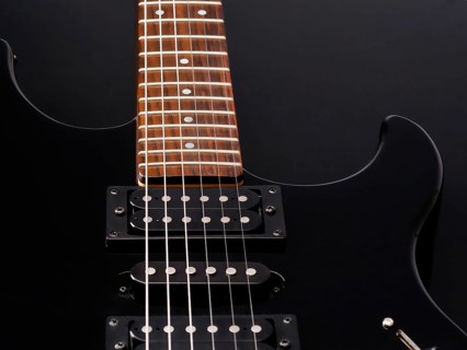 A detailed close up of a sleek black electric guitar with a wooden fretboard and shiny metal