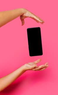 Crop anonymous person in casual clothes showing modern smartphone with empty screen while floating