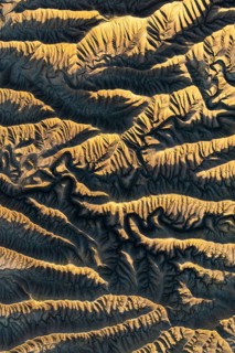 Capturing the intricate golden textures of Caineville Mesa, Utah, this aerial view reveals the