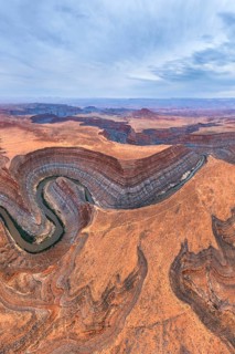 Aerial view of San Juan canyon with a winding river cutting through the arid desert landscape. The