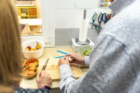 A couple with intellectual disabilities is preparing a healthy meal in a modern kitchen of a
