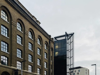 A striking juxtaposition of historic brick architecture with modern glass and steel structures in a