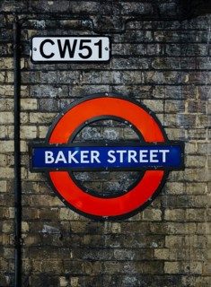A vibrant image of the Baker Street station sign on London's Underground, set against a textured