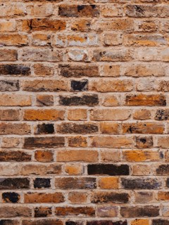 Detailed shot of a weathered brick wall showcasing natural textures and colors. This London-based