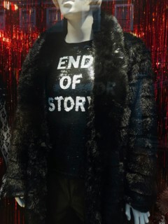 A fashionable mannequin in a London storefront displays a black faux fur coat and a sparkling