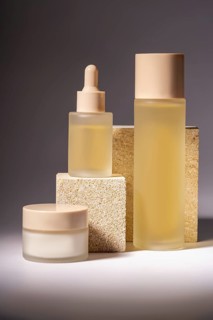 A stylish arrangement of cosmetic bottles in different sizes, showcased on textured stone podiums,
