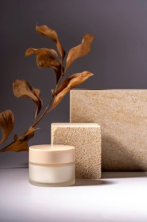 A stylish presentation of a cosmetic cream jar, set against a background of natural stone podiums