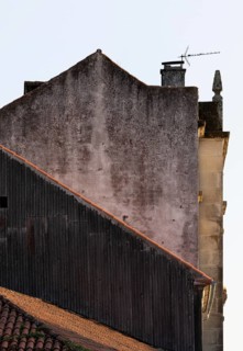 A close-up shot of aging, rustic rooftops with orange tiles, contrasting with the worn and