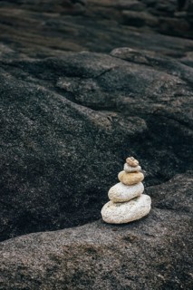 A stack of balanced stones on a rocky surface in a peaceful outdoor environment. Concept of