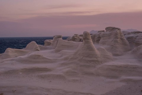 Serene evening view of the distinctive white rock formations at Sarakiniko Beach on the island of