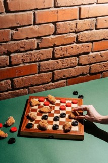A creative take on checkers using chicken nuggets as game pieces on a board, set against a rustic