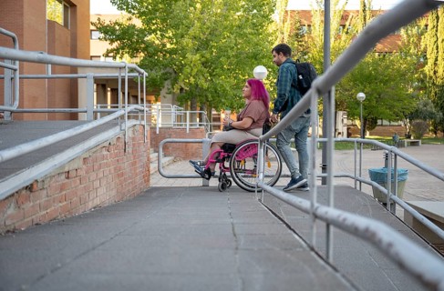 A couple navigating their college campus, with the woman using a wheelchair due to spina bifida