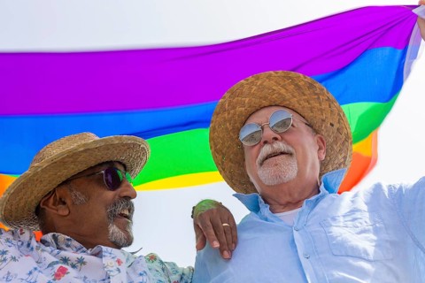 From below joyful gay senior couple, comprising two men, is captured outdoors, sharing a happy