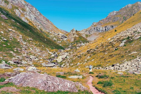 Back view of unrecognizable hikers on a trail in the Ibones de Anayet, Huesca, Spain. This image