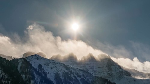 Dramatic winter morning with bright sun shining over the snow covered Les Dents du Midi peaks in