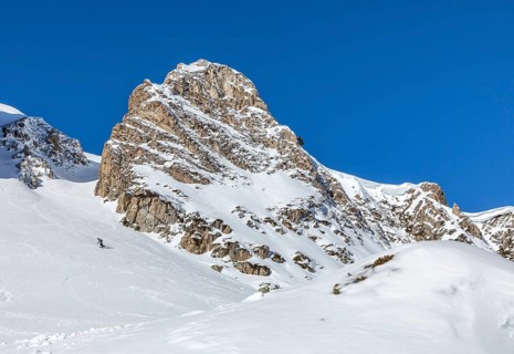 A stunning snow covered mountain peak under a clear blue sky, perfect for winter adventures and the
