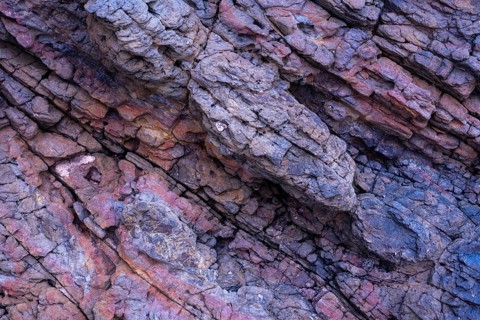 Close-up image displaying the intricate textures and varying colors of volcanic rocks at Mujeres