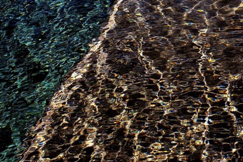 Abstract ripples on the water surface captured at Playa Blanca Port in Lanzarote, illustrating a