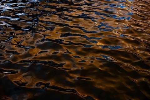 Captivating golden reflections dance on the rippling waters at Playa Blanca Port in Lanzarote,