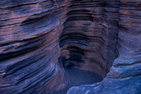 Intriguing photo capturing the detailed, layered rock formations inside Cueva de los Verdes on
