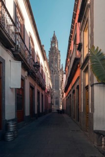 A serene cobblestone street leading to the iconic San Juan Bautista Church in Arucas, Gran Canaria,